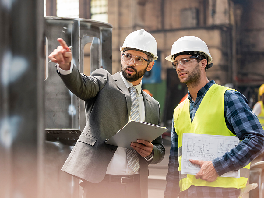 strategic planning wide Manager and steel worker talking strategy at factory